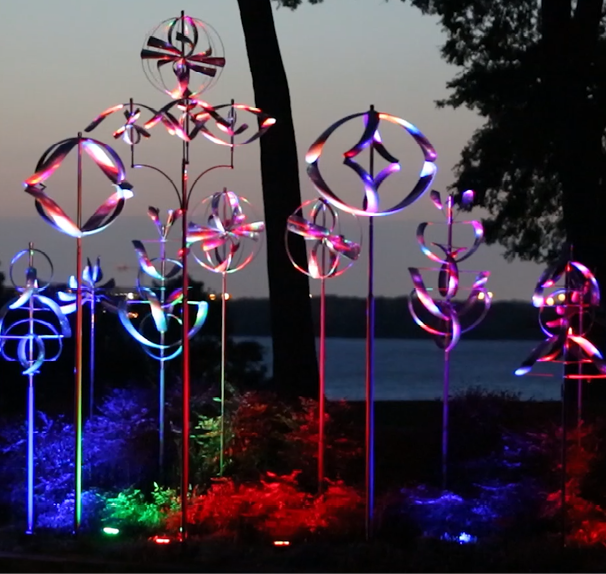 A group of colorful, illuminated sculptures are displayed in a park. AI generated content