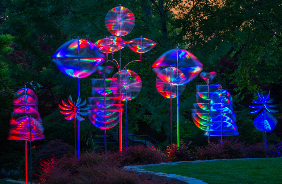 A row of colorful glass sculptures are on display. Description generated by AI