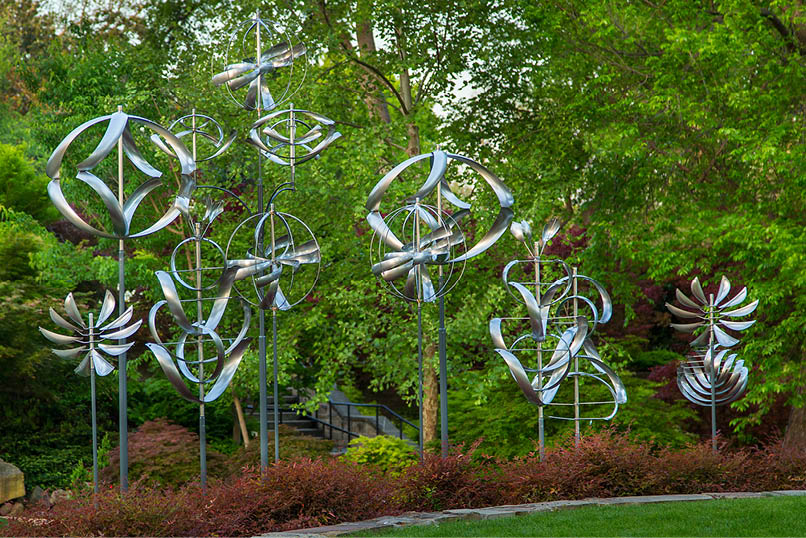 A row of metal sculptures in a garden. Description generated by AI