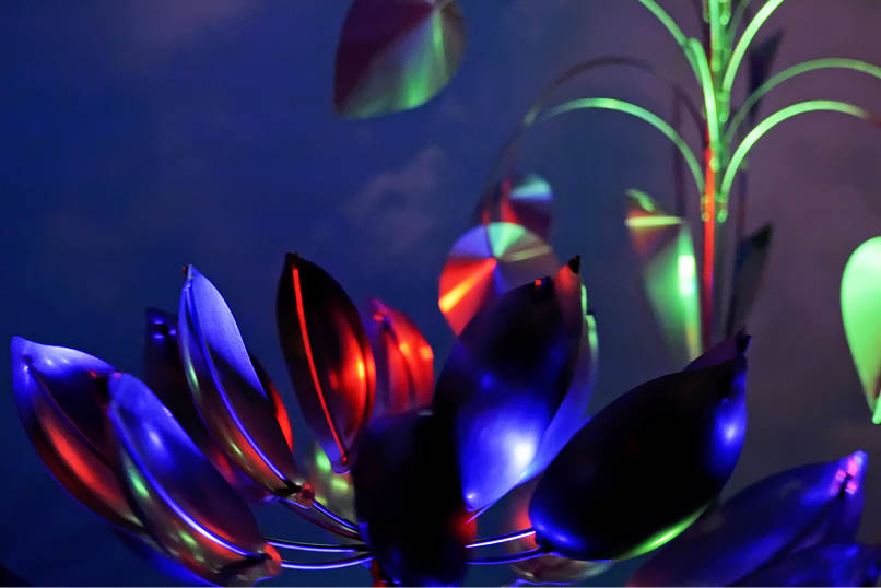 A blue and red lighted plant with a green stem. AI generated content
