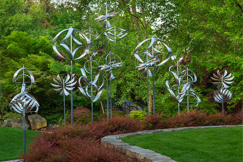 A row of metal sculptures in a garden. Description generated by AI