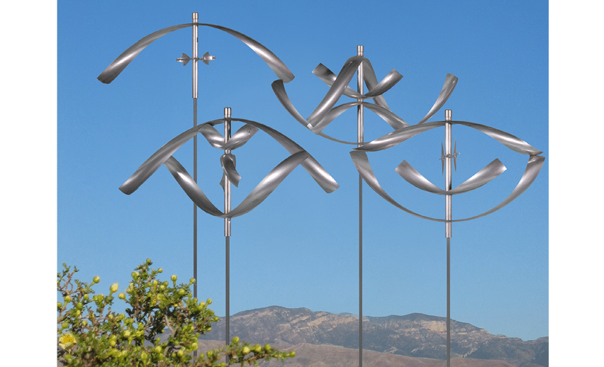 Two metal sculptures of fish are standing in front of a mountain. Description generated by AI