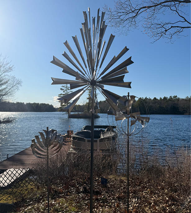 A windmill with a blue sky in the background. Description generated by AI