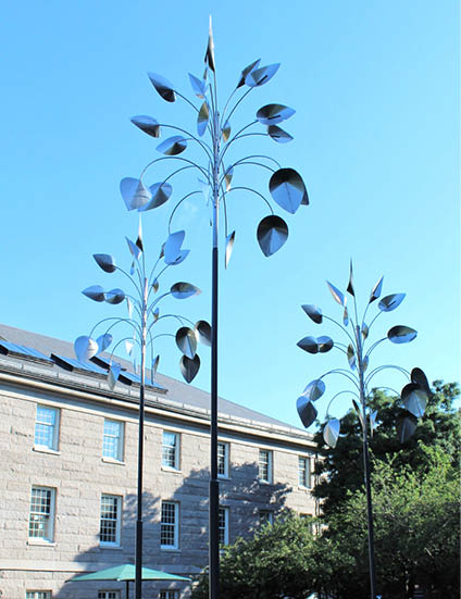 Two metal sculptures in a grassy area. Description generated by AI
