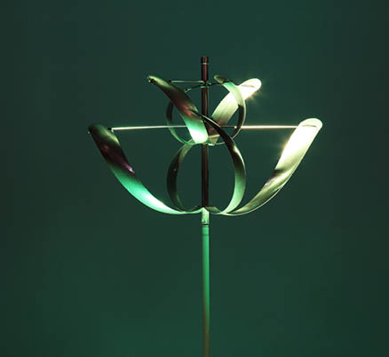 A green lighted sculpture of a flower. Description generated by AI