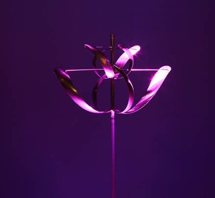 A purple lighted sculpture of a flower. Description generated by AI