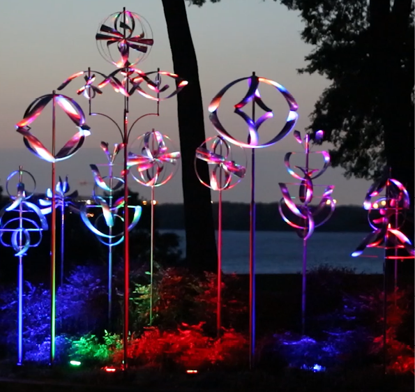 A group of colorful, illuminated sculptures are displayed in a park. AI generated content