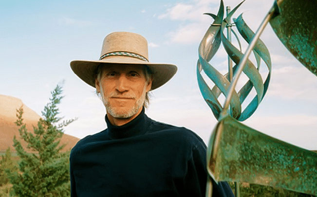 A man wearing a cowboy hat and a blue shirt. Description generated by AI