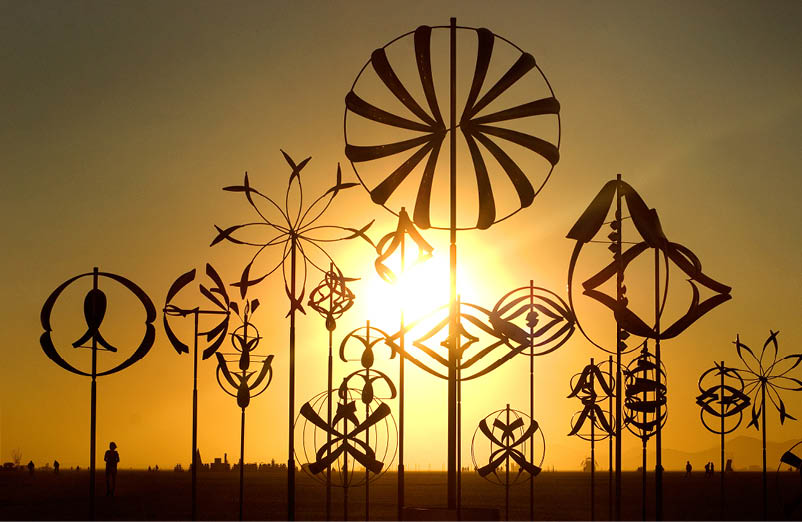 A row of wind catchers with various designs are displayed in front of the sun. AI generated content