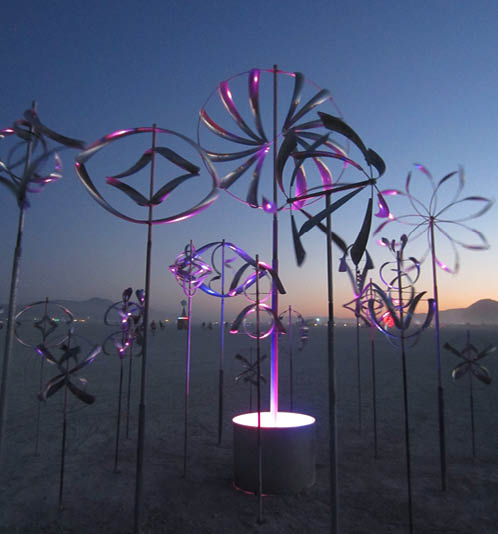 A group of metal sculptures are on display in a sandy area. AI generated content